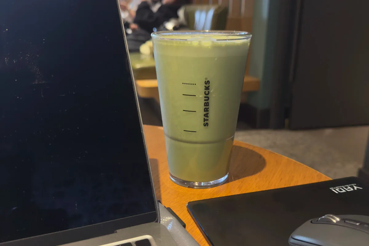 咖啡廳桌上的 MacBook、抹茶飲品與滑鼠;搭配效率上升、需求持平的概念排版